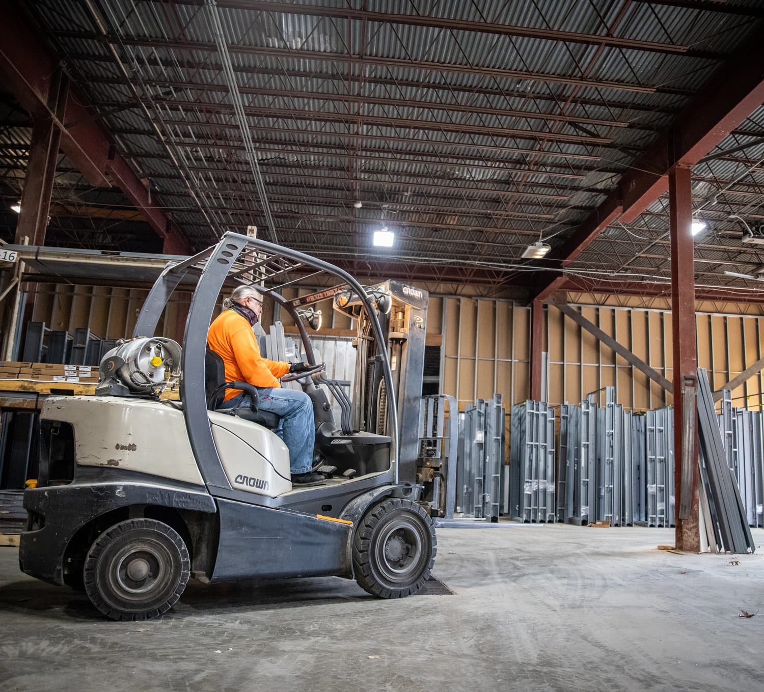 man driving forklift in custom door shop